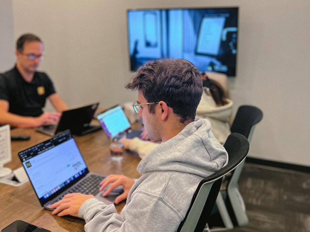 Quentin, Bruno et Majda travaillent sur l'ordinateur dans nos bureaux