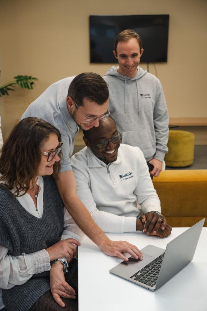 Employés de Numigi (Valérie Pottier, Romain Joliveau, Henri Tamouya, Julien Jézéquel) réunis devant un ordinateur chez Hedhofis.
